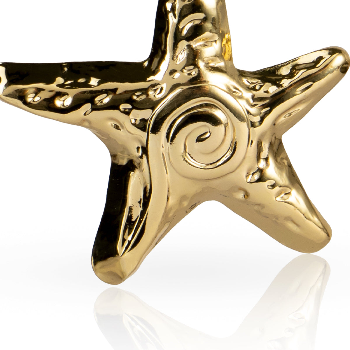 Gold starfish-shaped earring on a white background