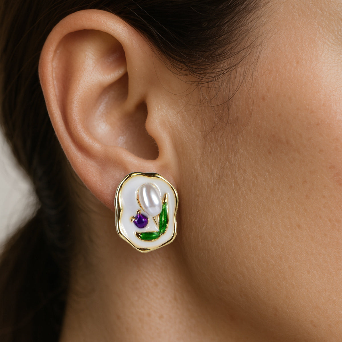 Close-up of an earring with a pearl and gemstones.
