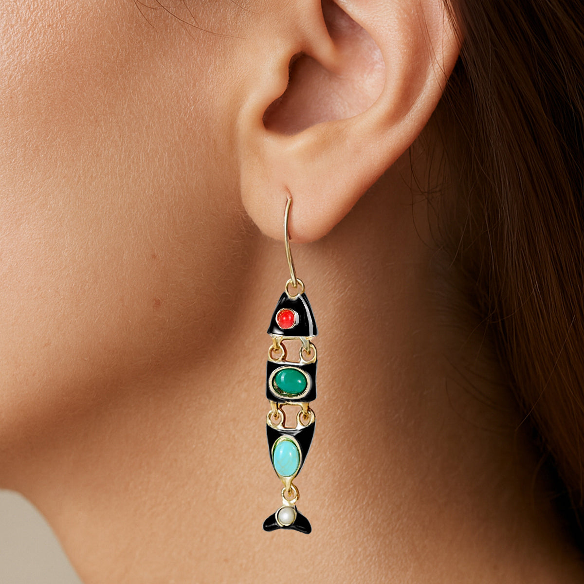 Close-up of a model wearing a colorful fish-shaped earring.